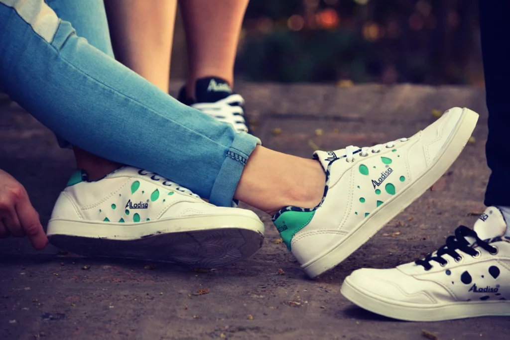 Grupa osób odpoczywająca na zewnątrz, ubrana w modne, codzienne sneakersy, w swobodnej pozie.